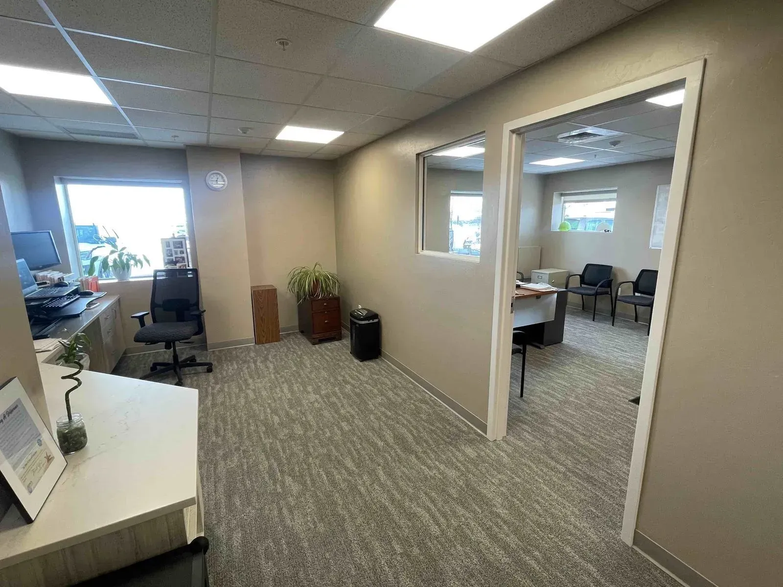 Office interior with two rooms, carpet, desk, and chairs