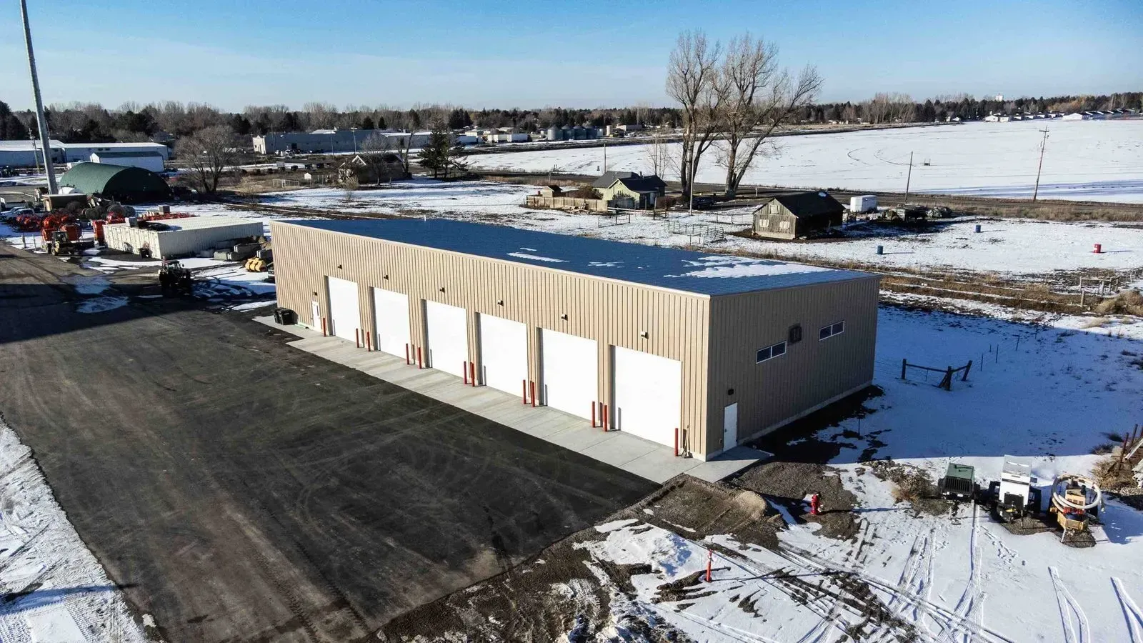 An aerial view of a large building in the middle of a snowy field.
