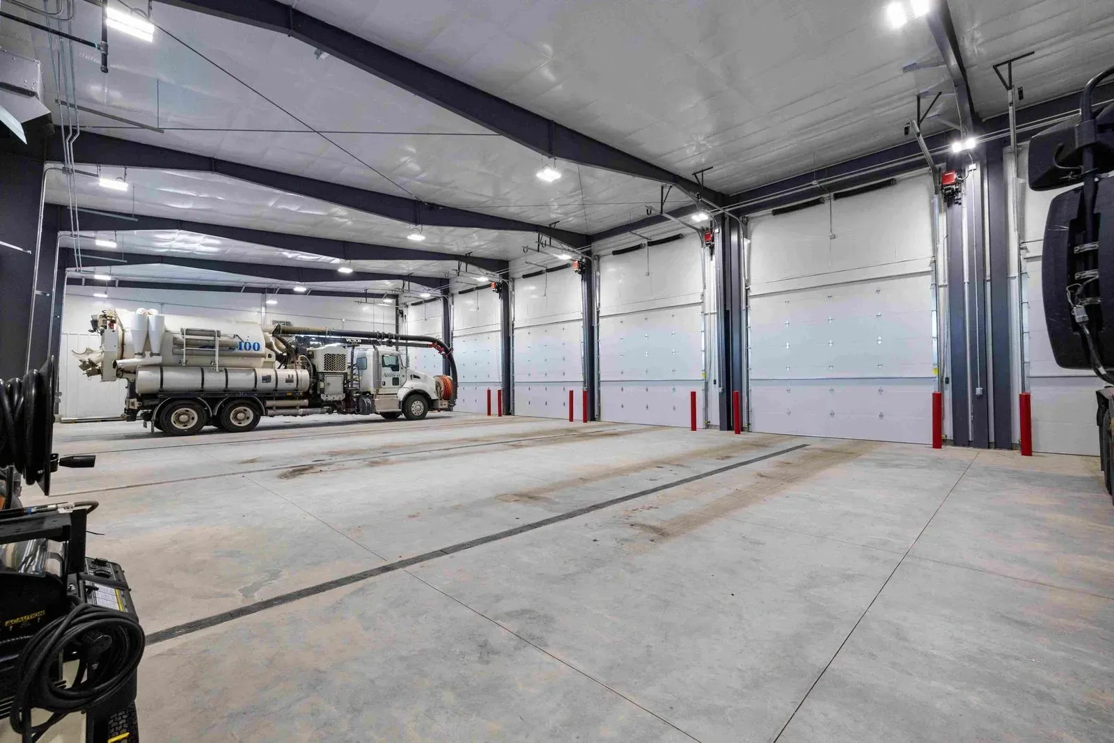 Two trucks are parked inside of a large building.