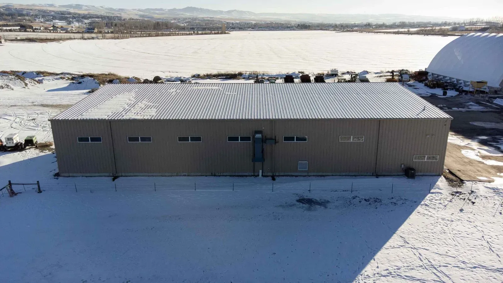 An aerial view of a large building in the middle of a snowy field.