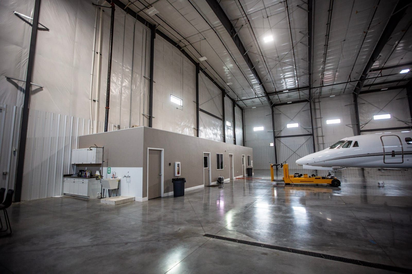 A small plane is parked in a large hangar.