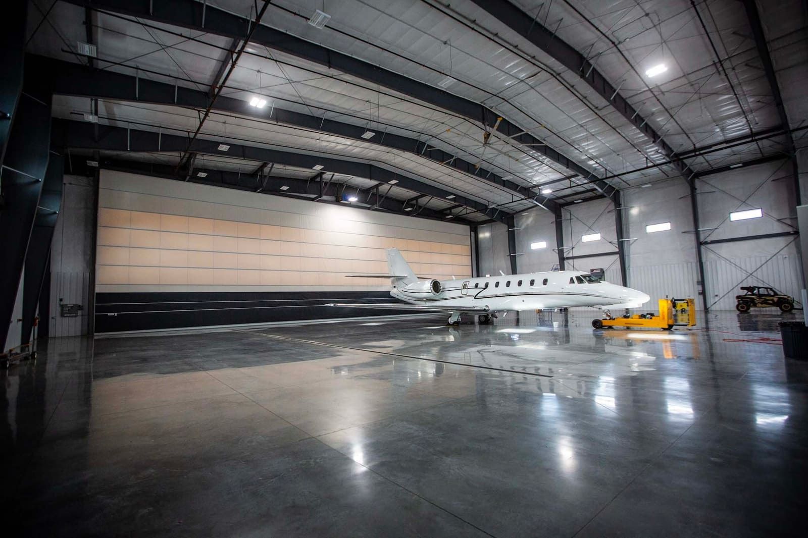 A private jet is parked in a large hangar.