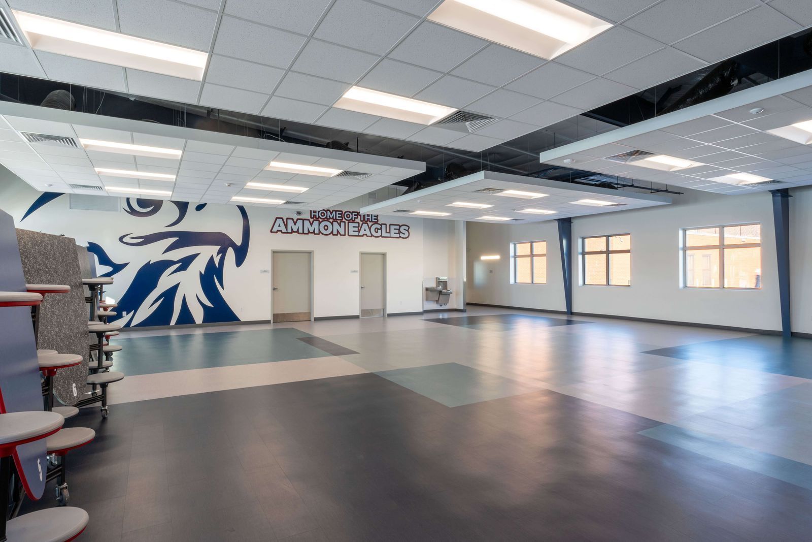 A large empty room with a mural on the wall.