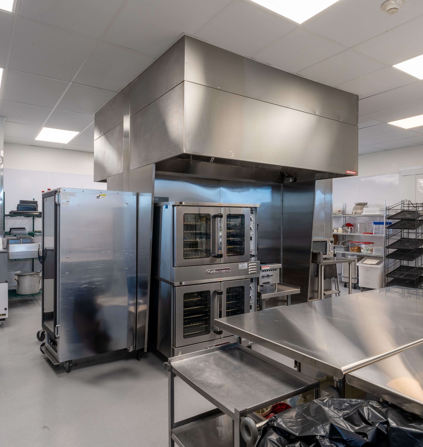 A kitchen with stainless steel appliances and tables