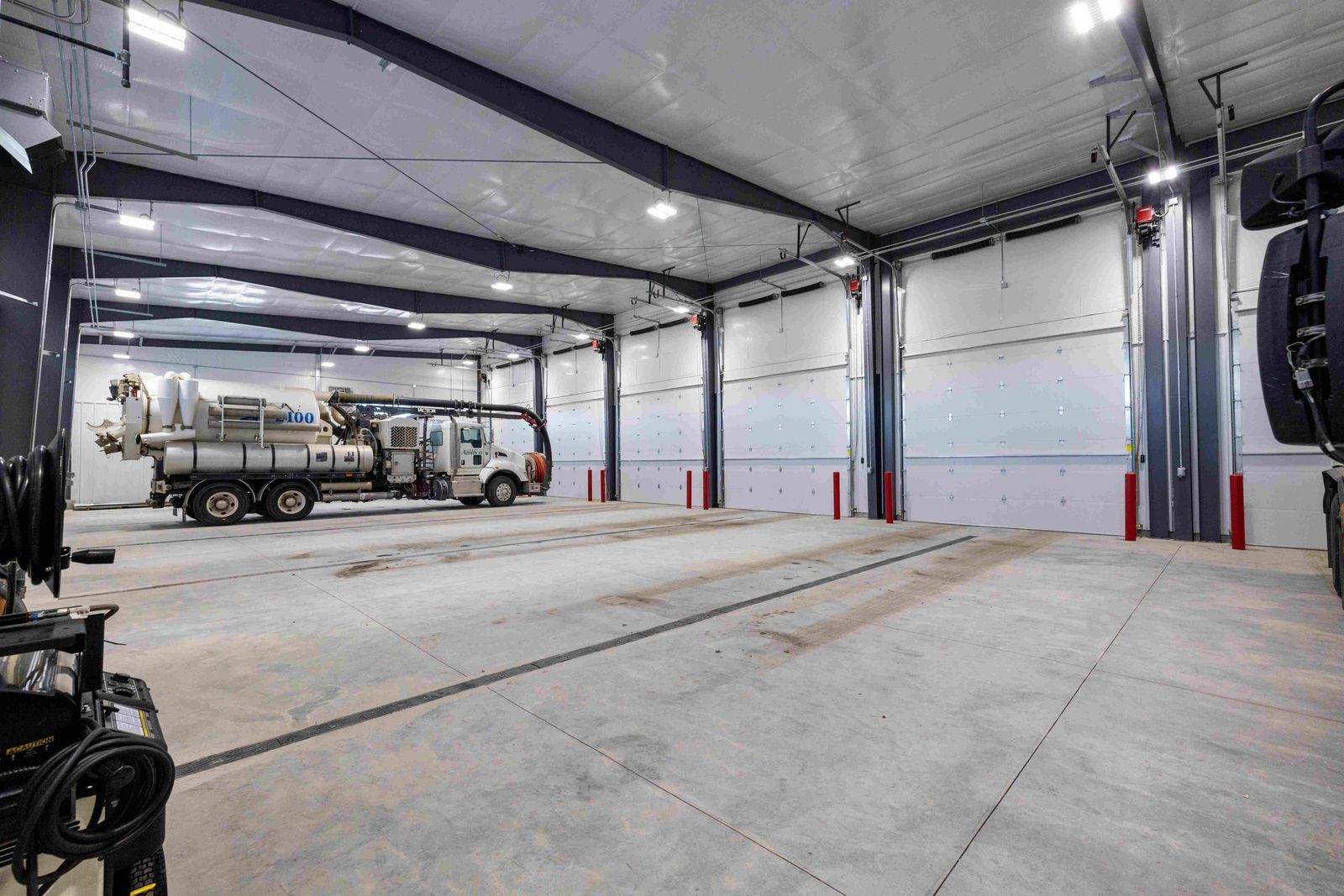 Two trucks are parked inside of a large building.