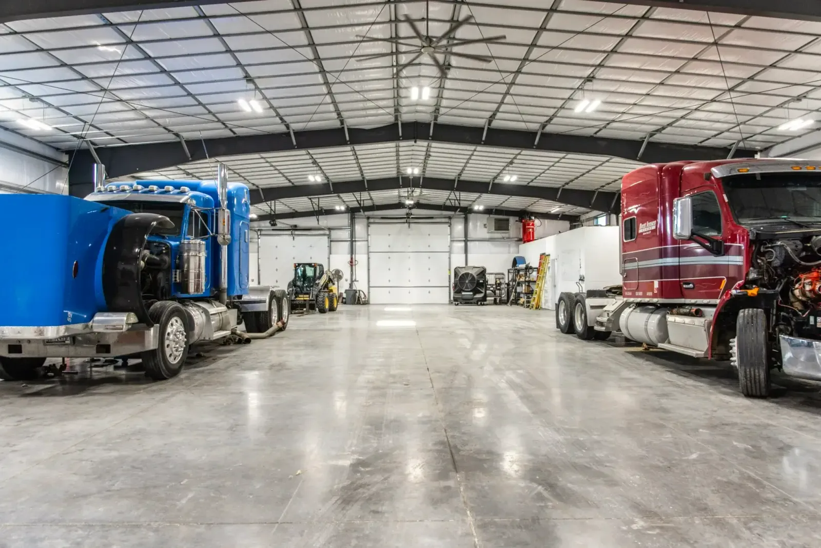 Interior of a large garage with two semi-trucks