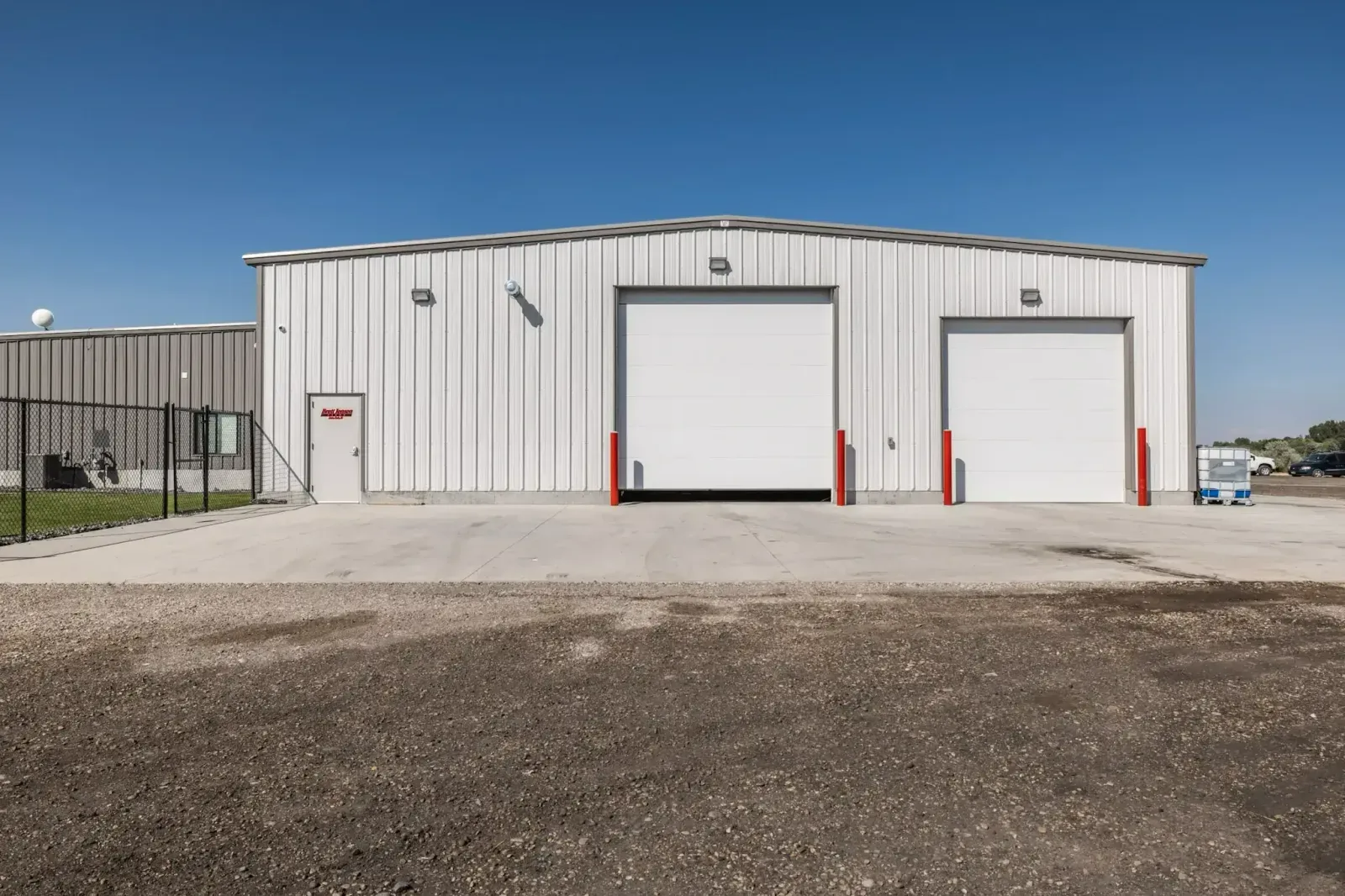 White metal warehouse with two large garage doors