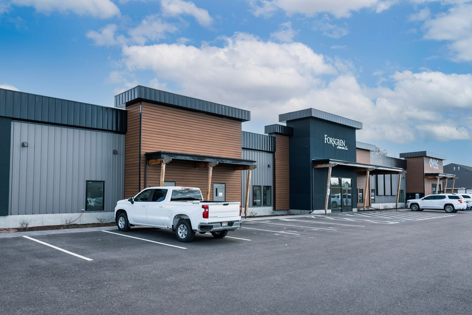 A white truck is parked in front of a building