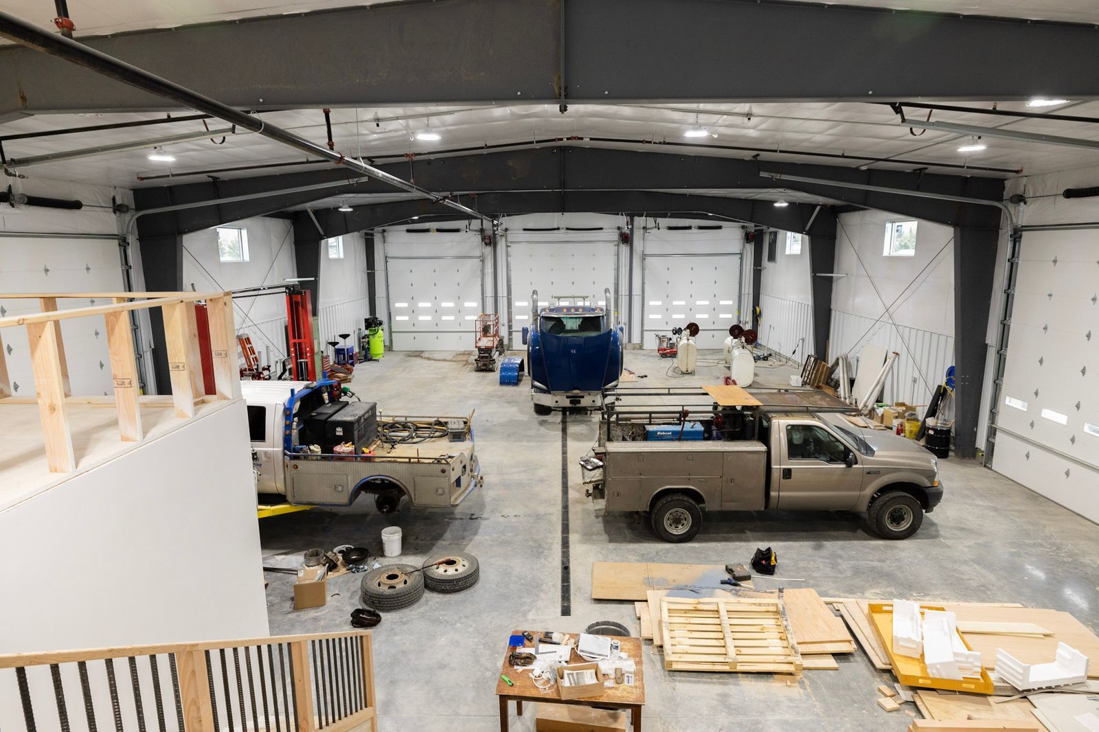 A large warehouse with trucks parked inside of it.