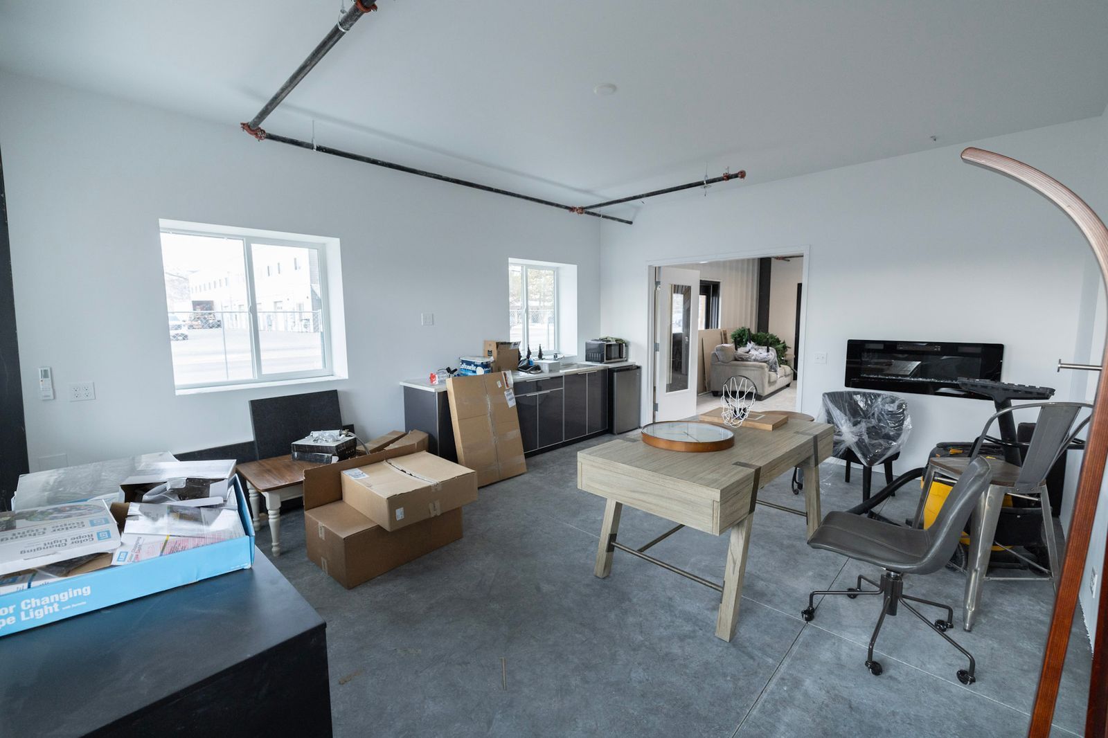 A room with a table and chairs and boxes on the floor.