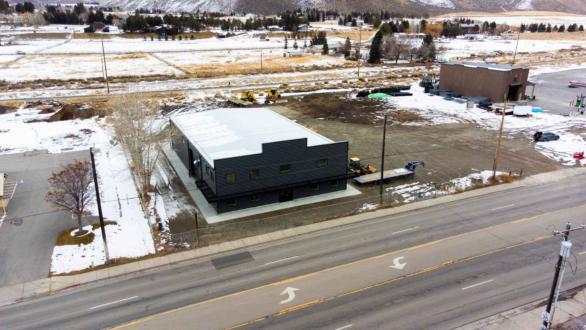 An aerial view of a building sitting on the side of a road.