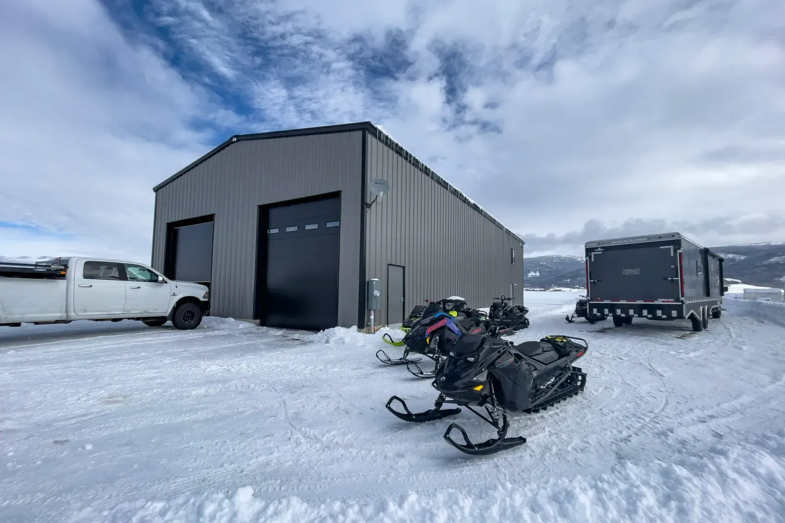 A snowmobile is parked in front of a building in the snow.