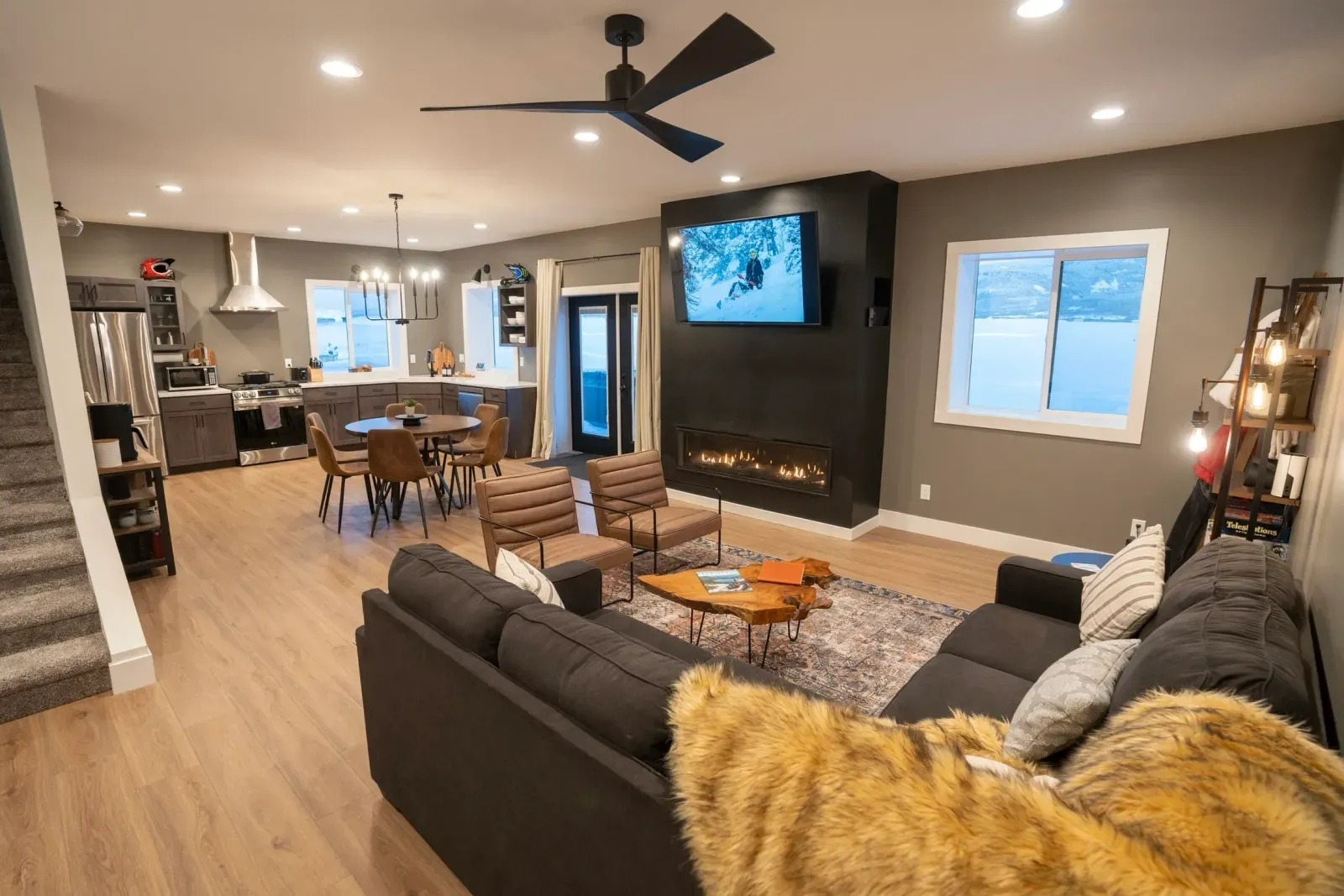 A living room with a couch , chairs , a television and a fireplace.