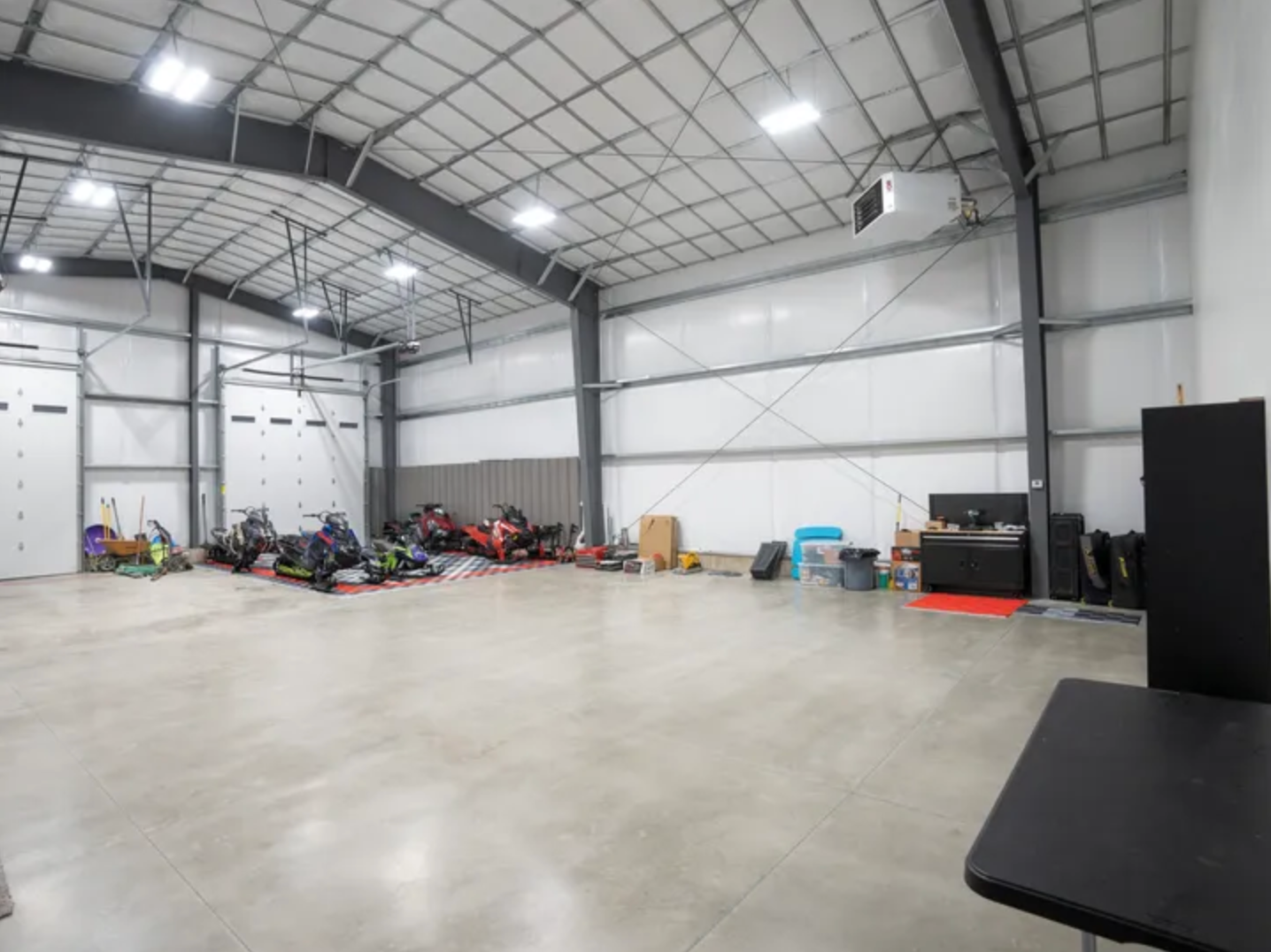 A large warehouse with a lot of vehicles inside of it.