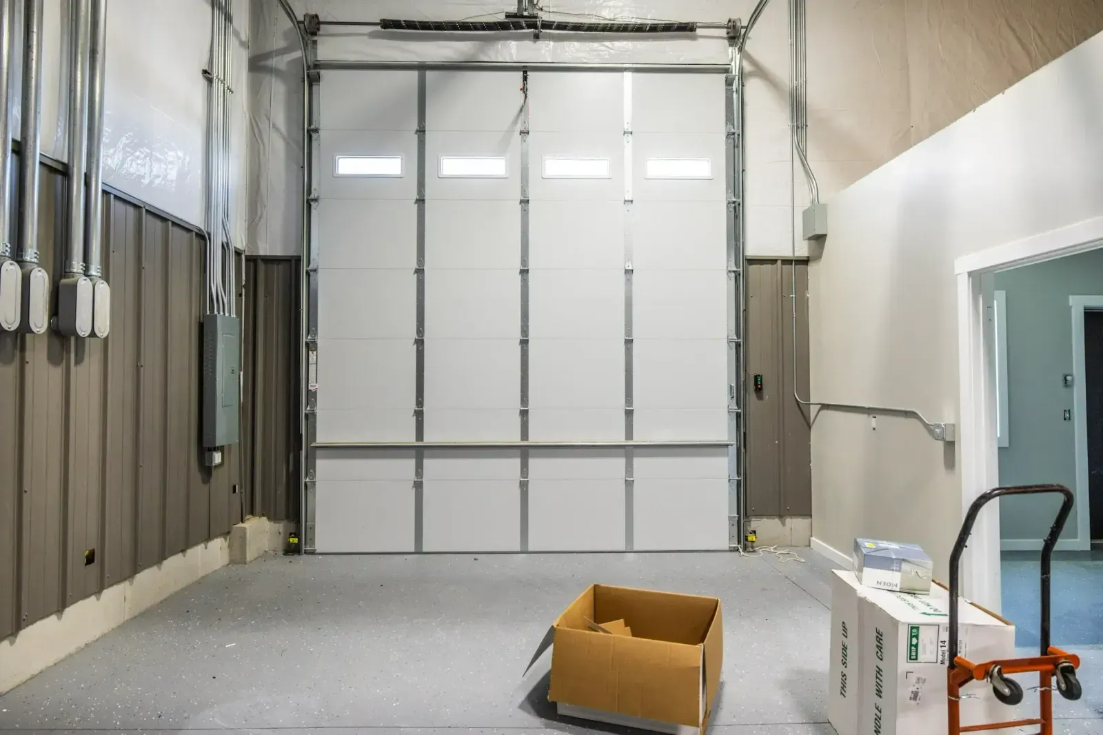 A cardboard box is sitting in a garage next to a garage door.