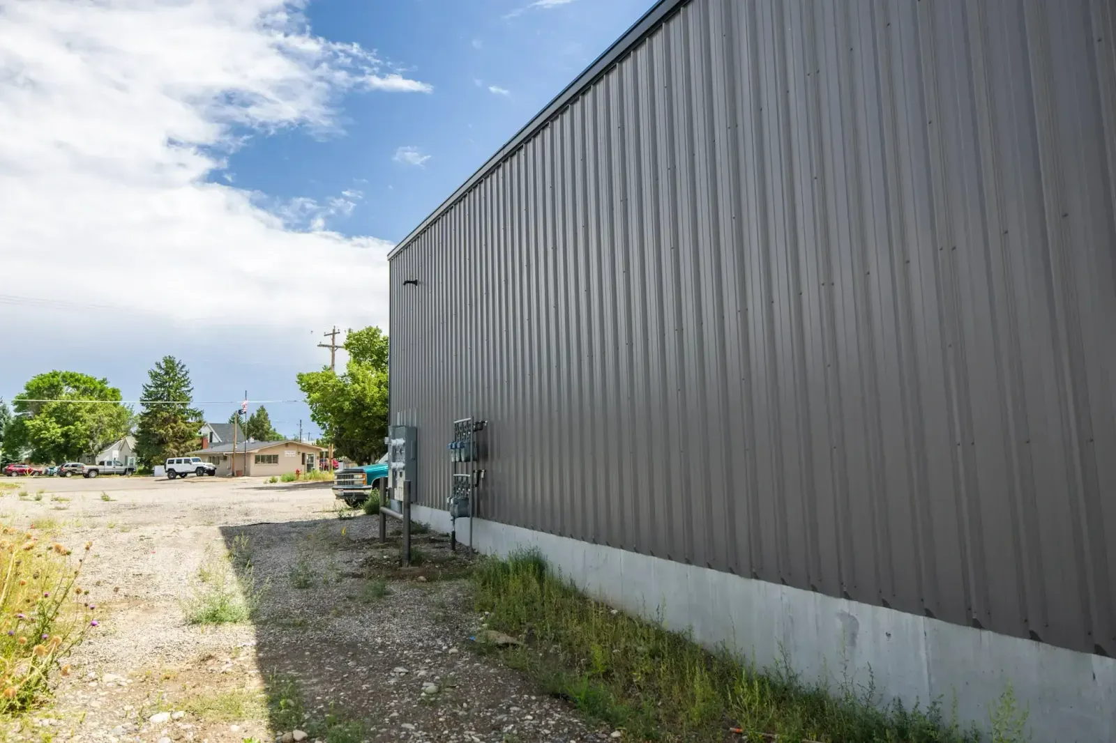 A large gray building with a lot of grass on the side of it.