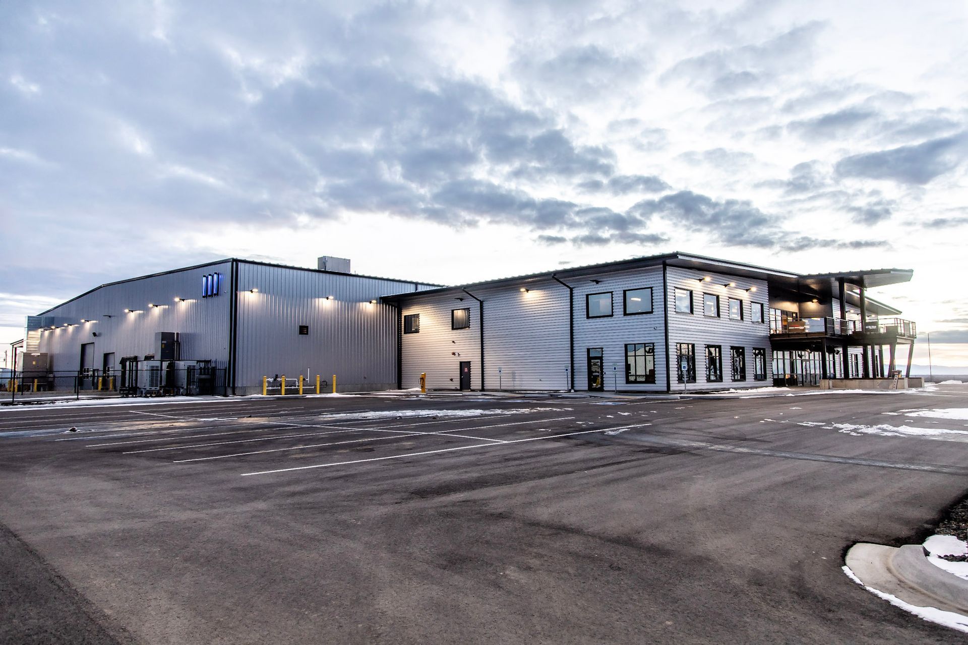 A large building with a lot of windows and a parking lot in front of it.