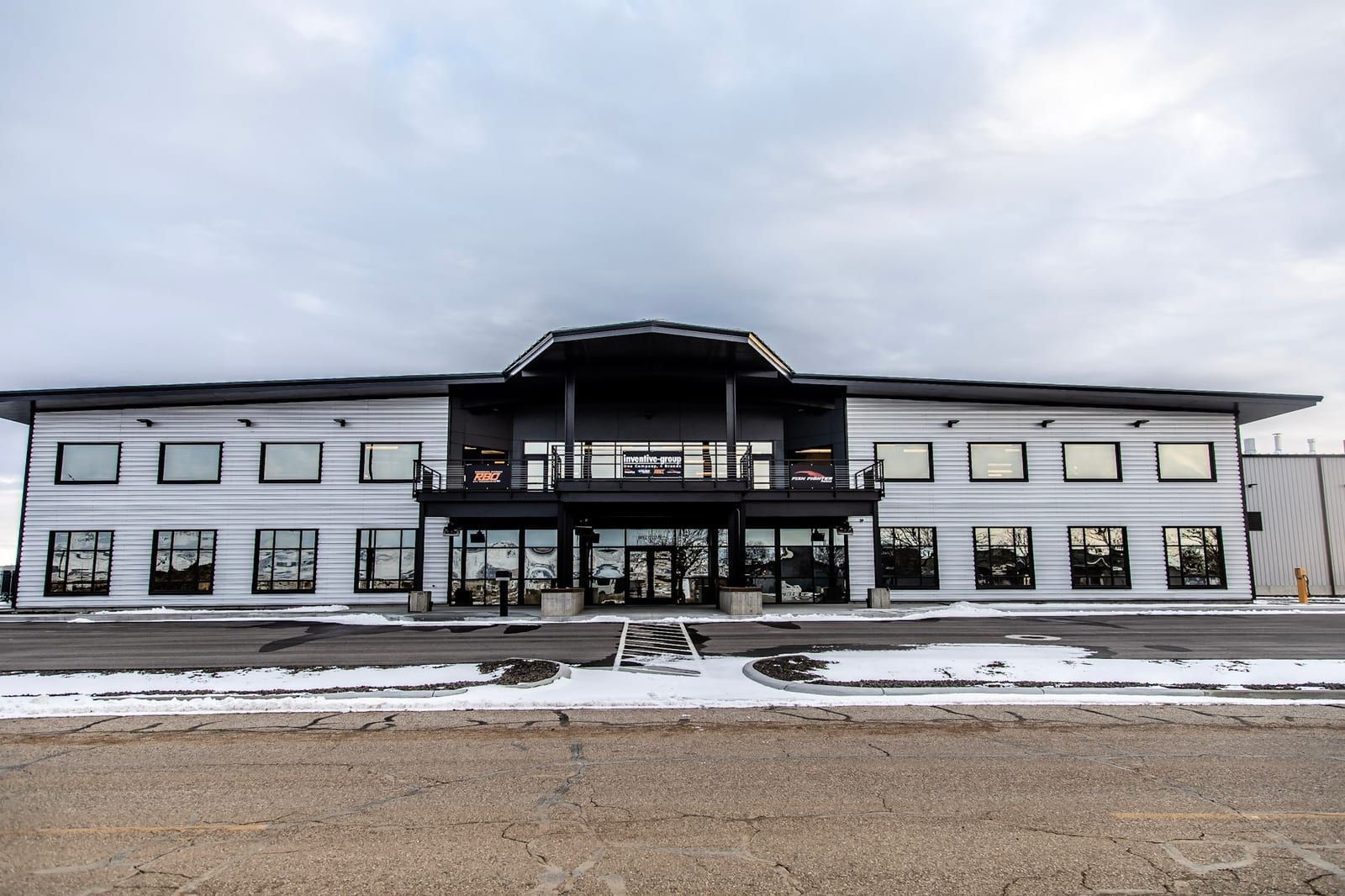 A large building with a lot of windows is sitting on the side of the road.