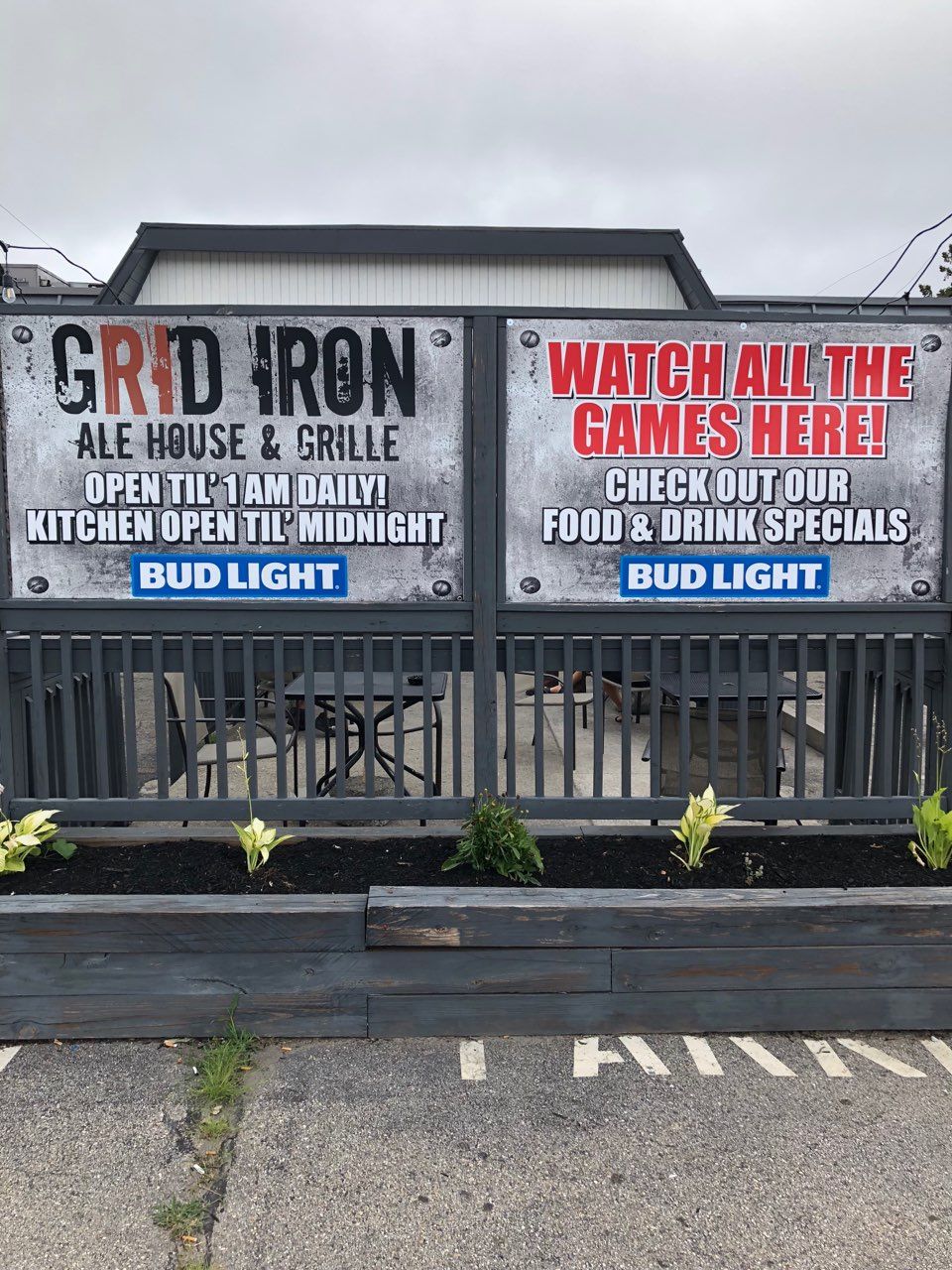 A sign for grid iron ale house and grille says watch all the games here.