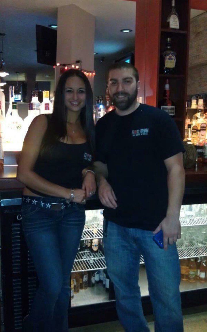 A man and a woman are posing for a picture in a bar