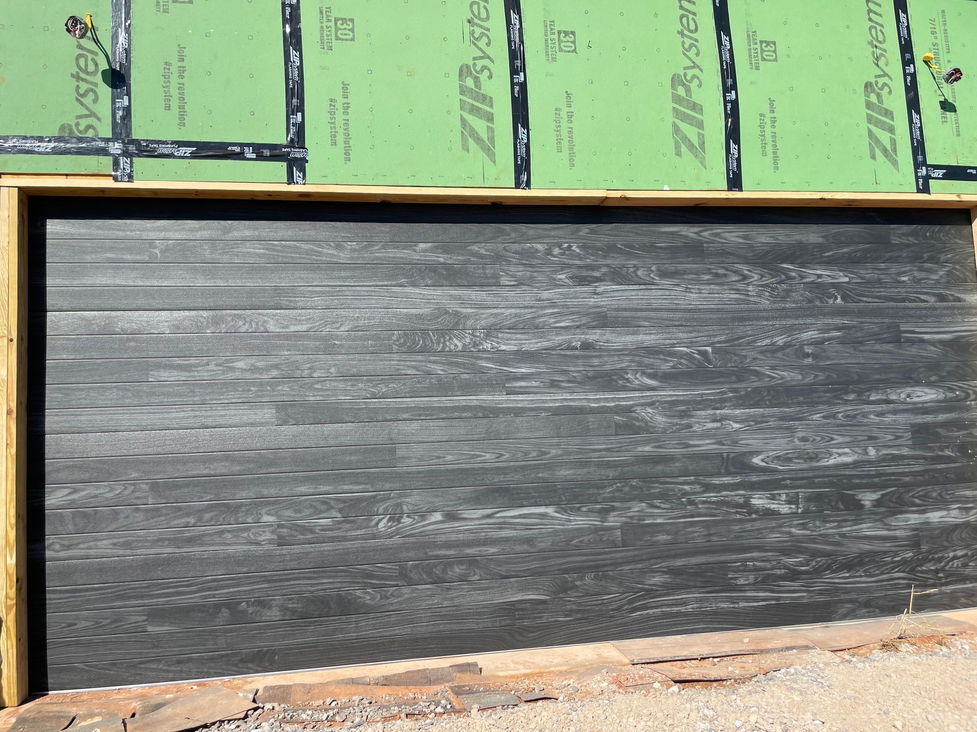 Blackboard with wooden frame beneath green wall insulation panels