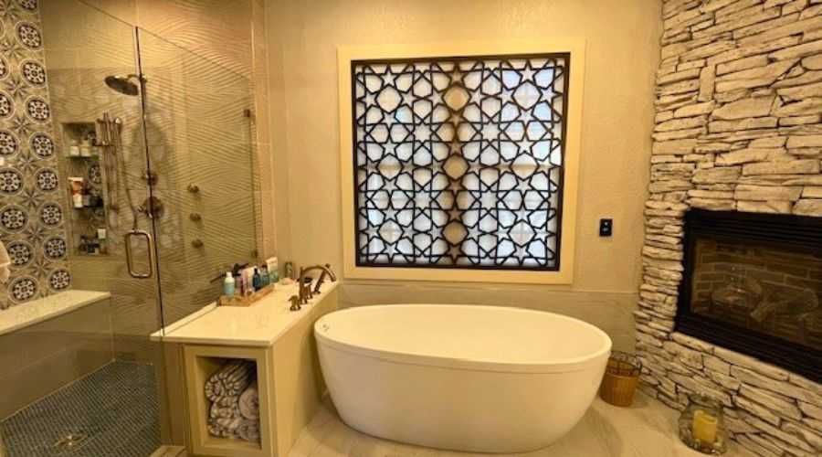 Luxury bathroom with freestanding tub, stone walls, decorative window, and walk-in shower