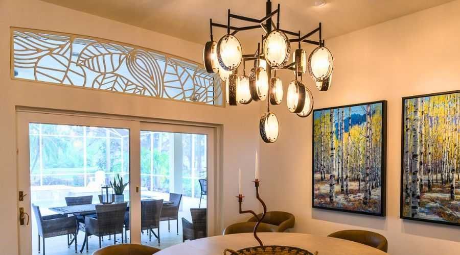 Modern dining room with chandelier, large sliding doors, and colorful wall art