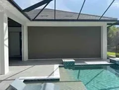 Large outdoor shade screen on a patio, overlooking a pool.
