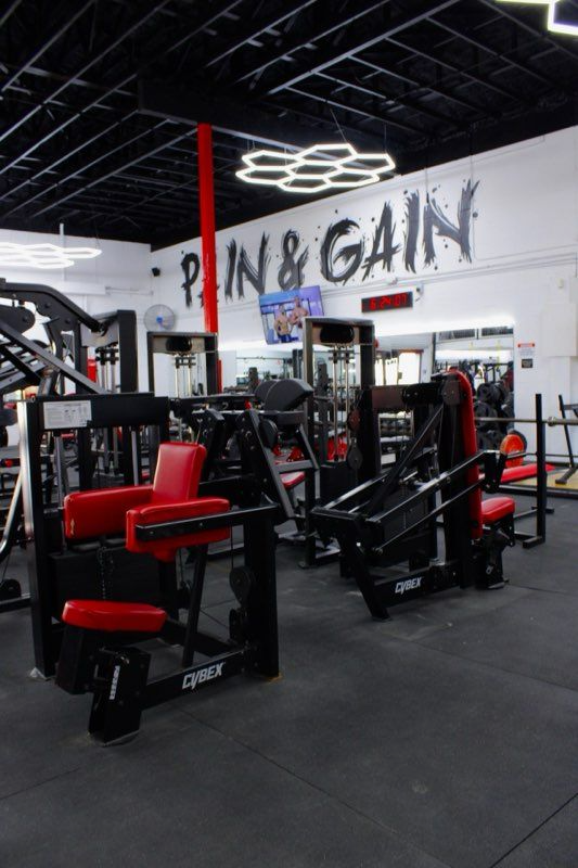 Gym interior with red and black exercise machines. 
