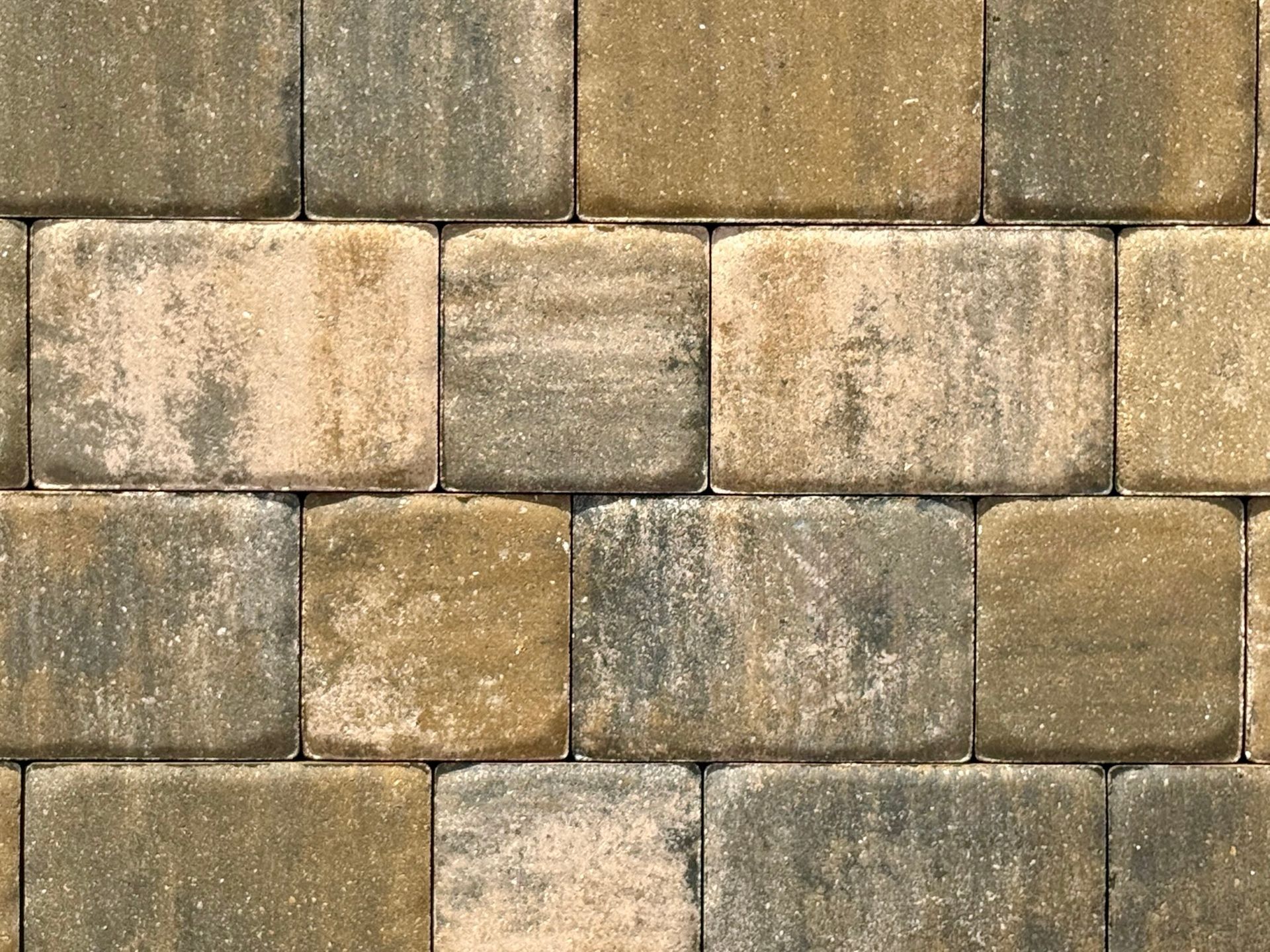 A close-up of a brick wall with gray and tan bricks.