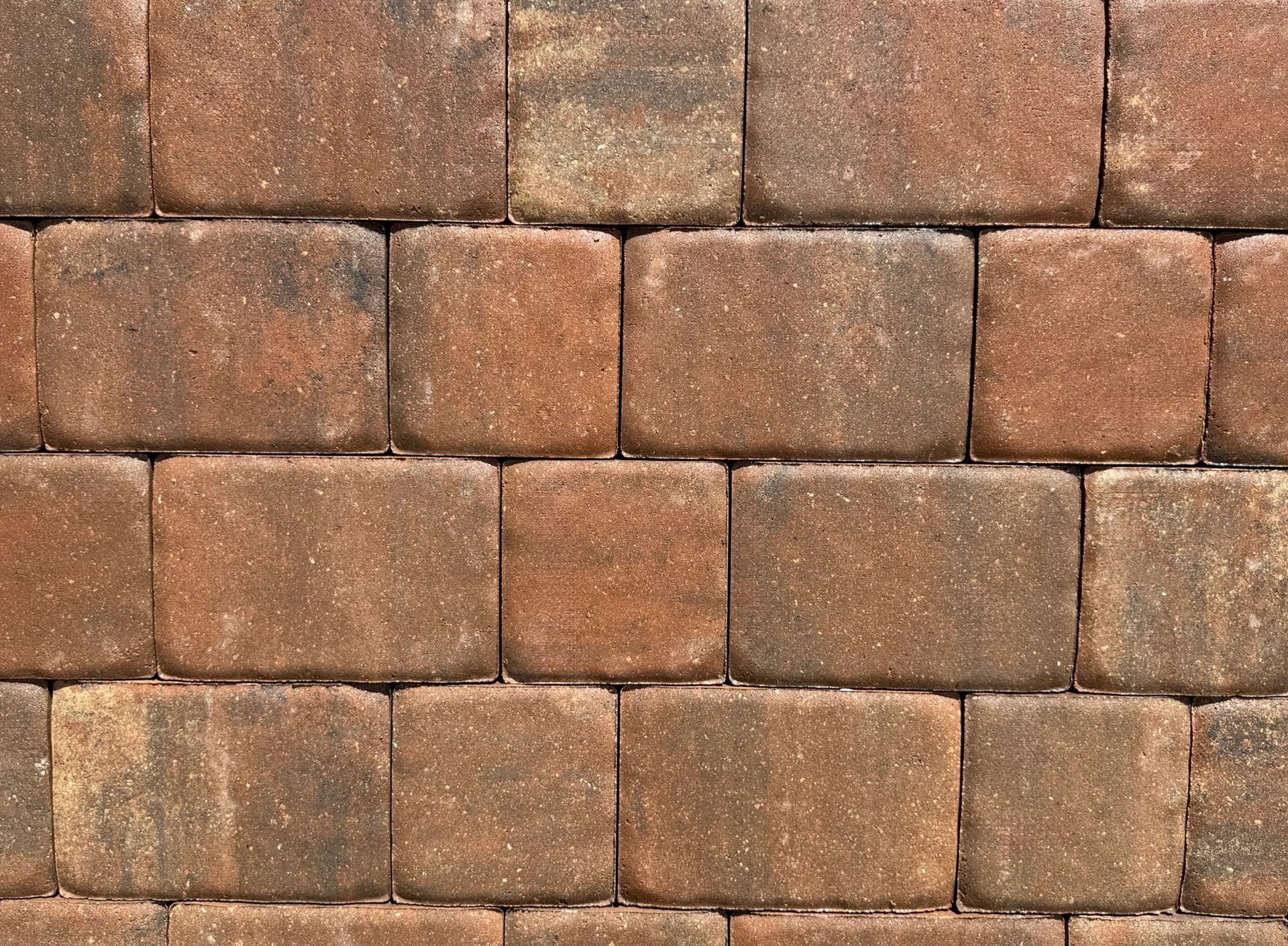 A row of brown bricks with white spots on them.