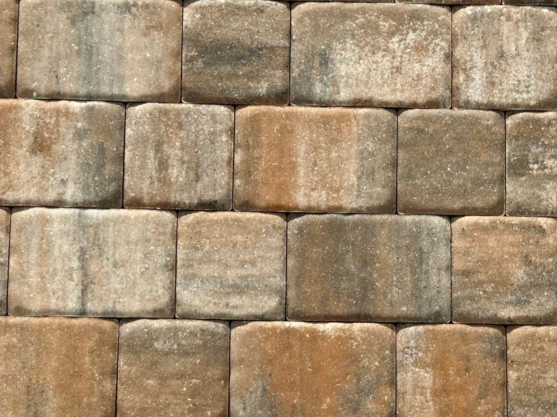A close-up of a brick wall with a gray and brown brick pattern.