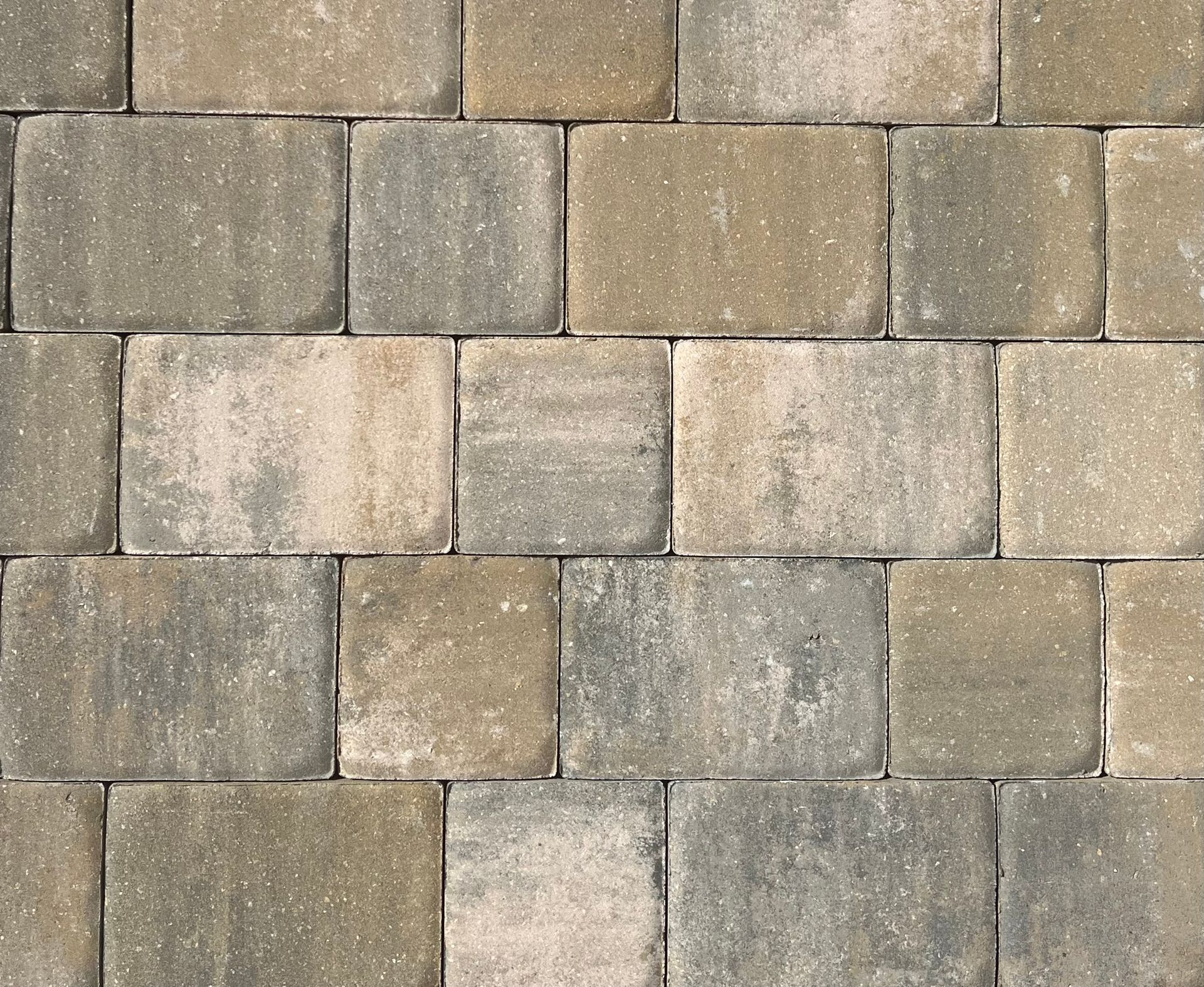 A close-up of a brick wall with gray and tan bricks.