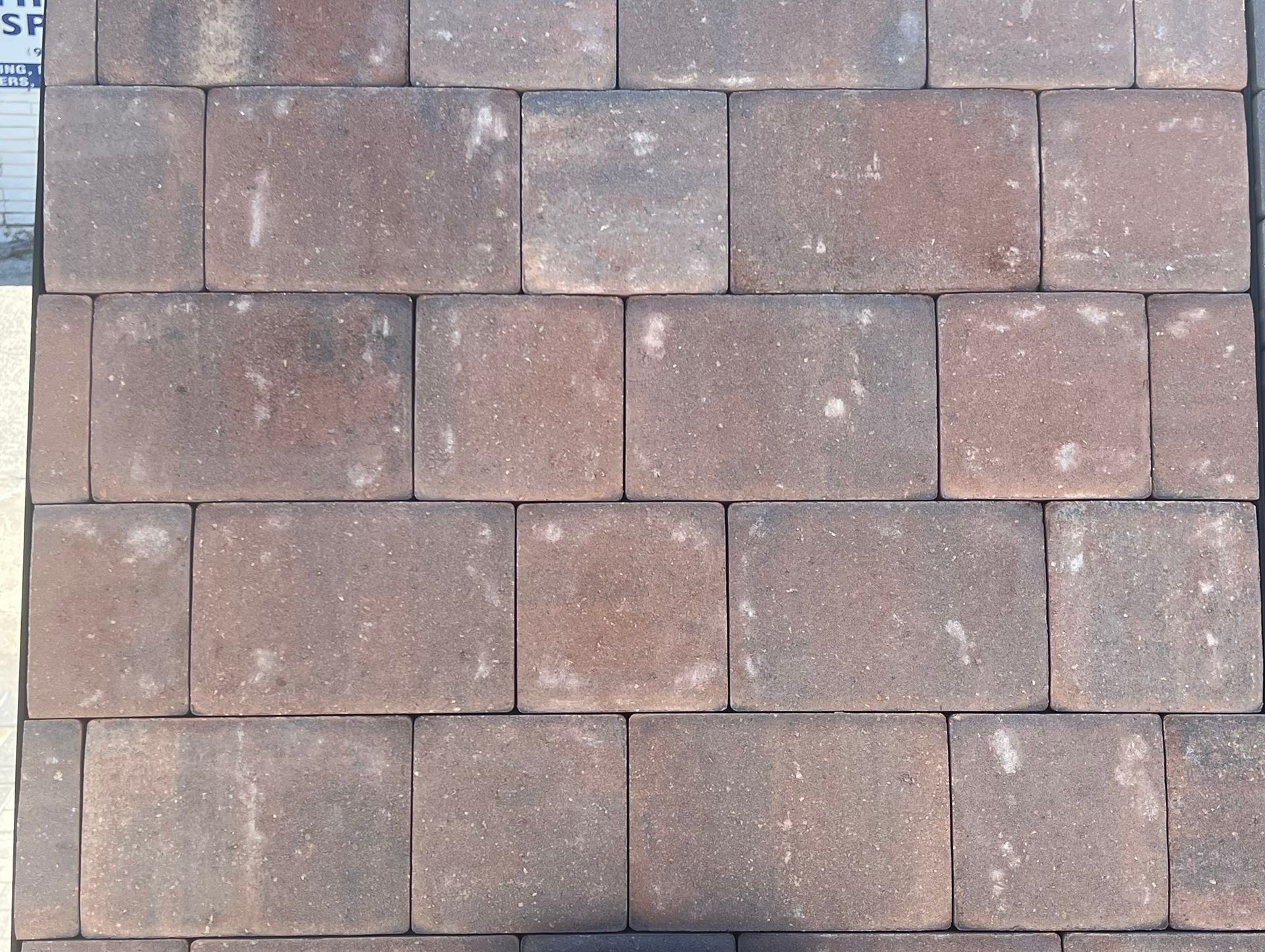 A row of brown bricks with white spots on them.