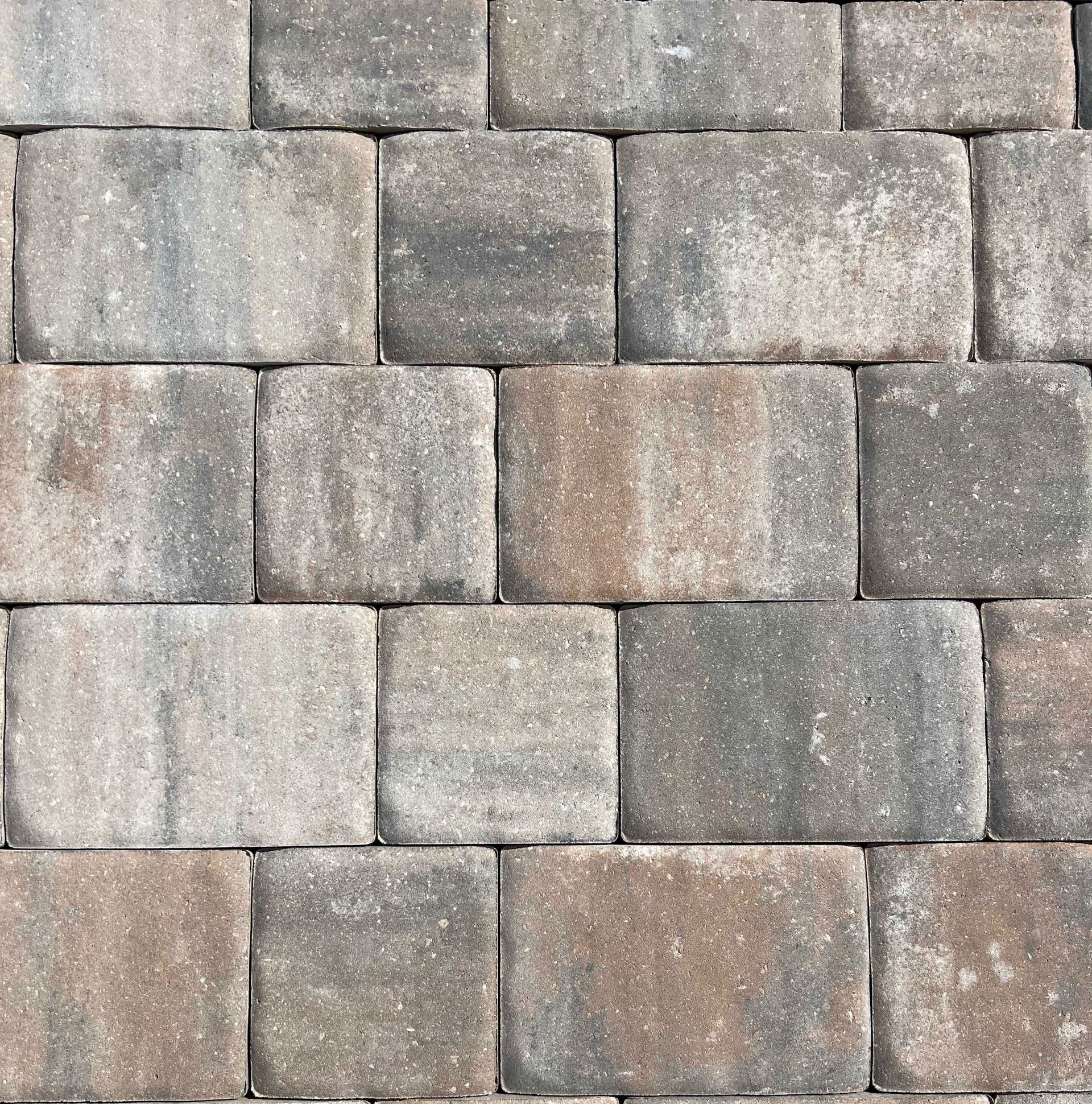 A close-up of a brick wall with a gray and brown brick pattern.