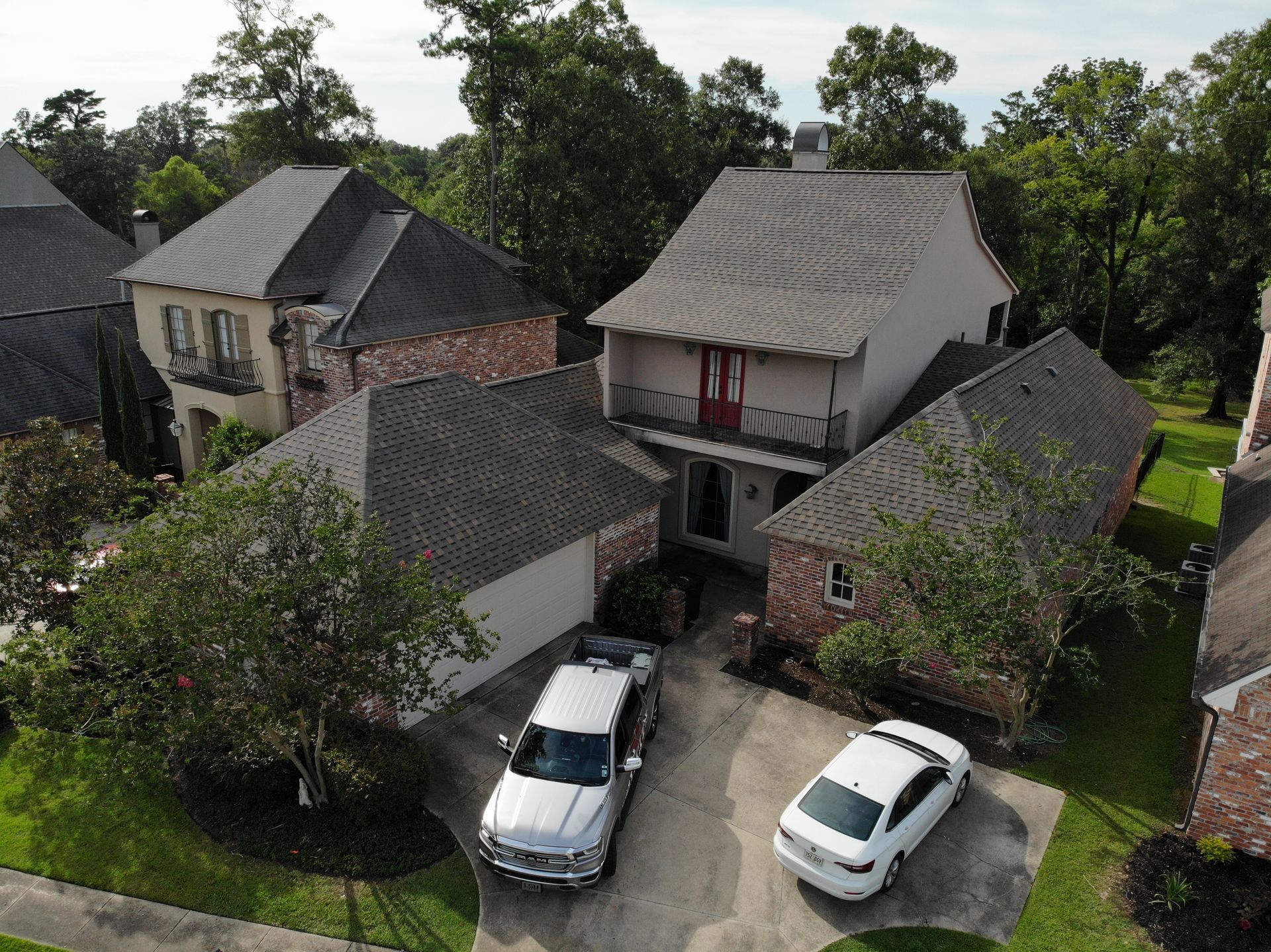 Top of the house dark asphalt roof with 2 white vehicles