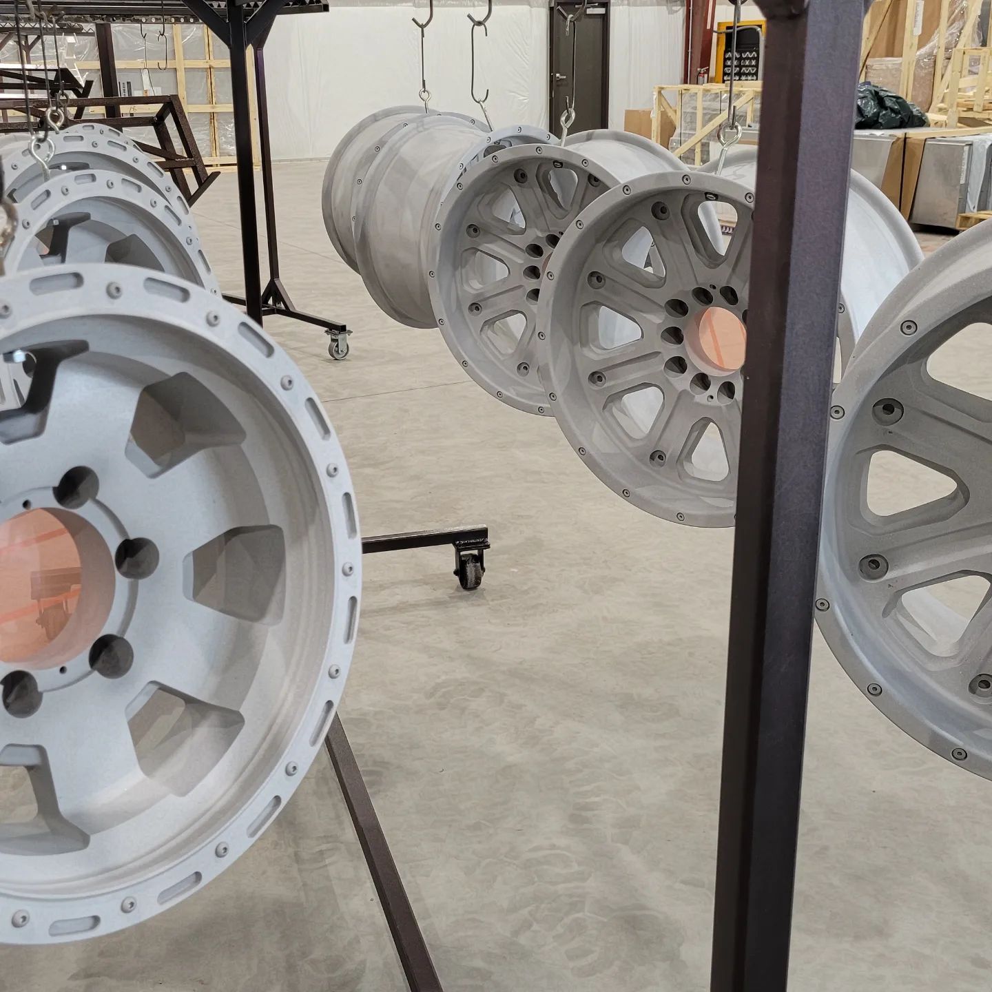 A bunch of wheels are hanging on a rack in a warehouse