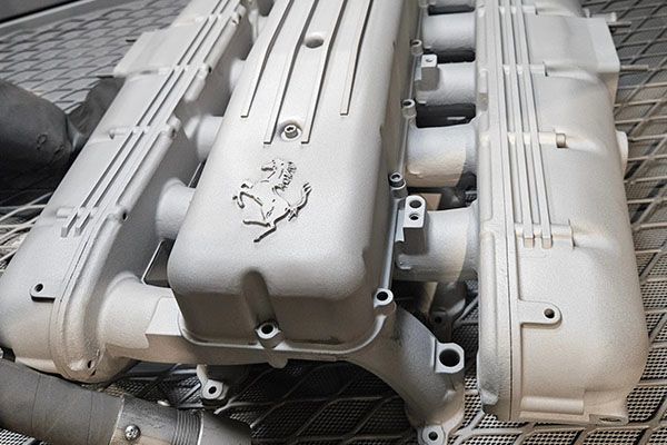 A ferrari engine is sitting on a metal surface.