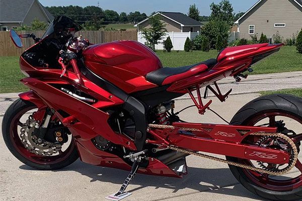 A red motorcycle is parked on the side of the road