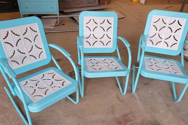 Three blue chairs with a pattern on the seats