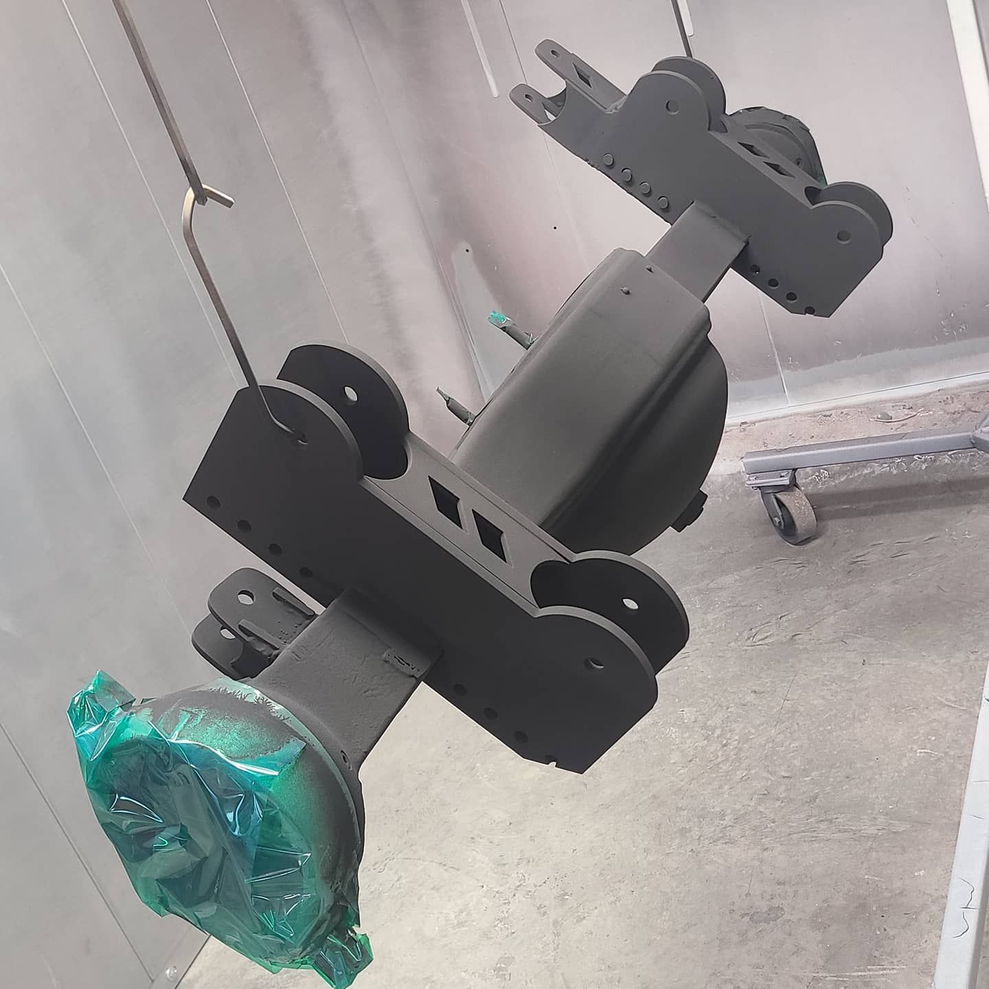 A piece of metal is hanging from a hook in a room