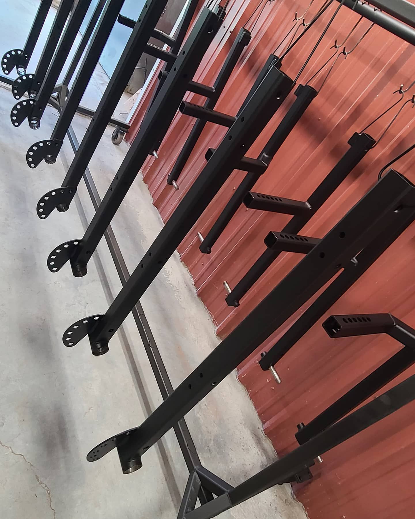 A bunch of black tubes are hanging on a rack