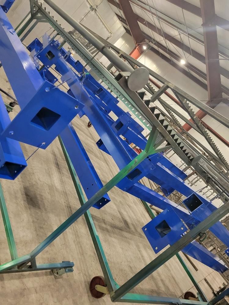 A bunch of blue pieces of metal are sitting on top of each other in a warehouse.