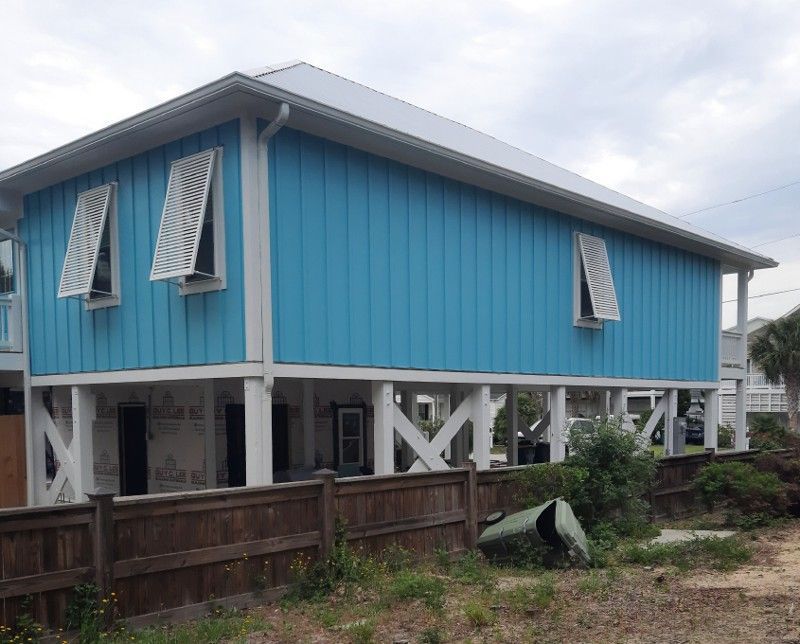 A blue and white house with shutters on the windows