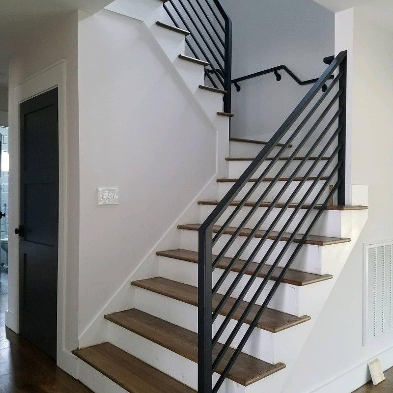 A staircase with a black railing and wooden steps