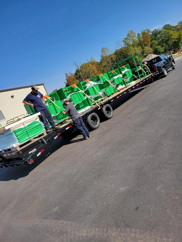 A truck is carrying a load of green boxes on a trailer.