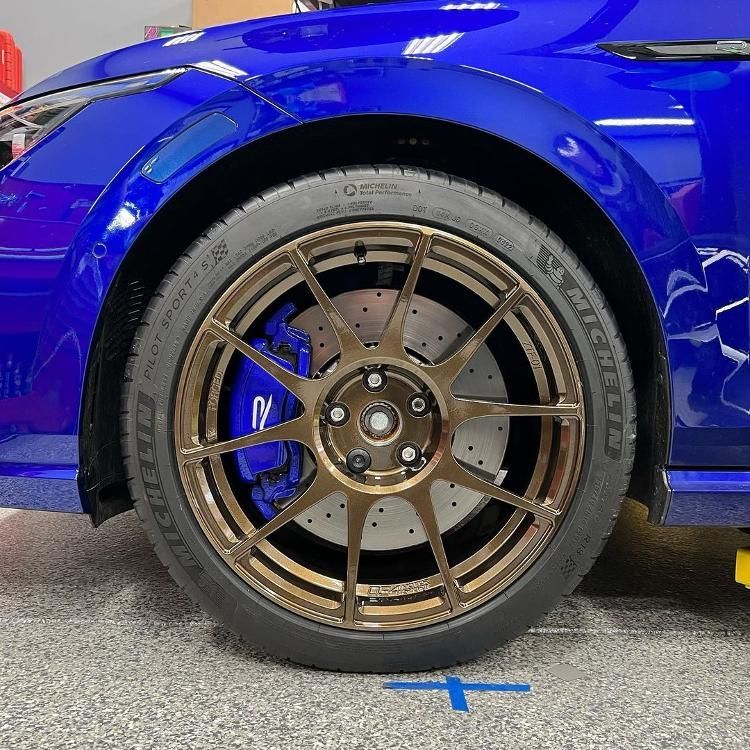 A close up of a blue car with a michelin tire on it.