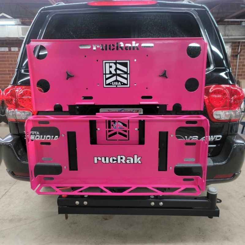 A black suv with a pink rucrak license plate holder