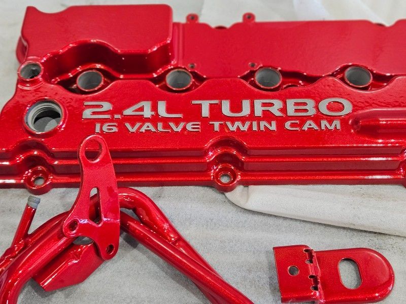 A red engine cover that says 2.4l turbo 16 valve twin cam