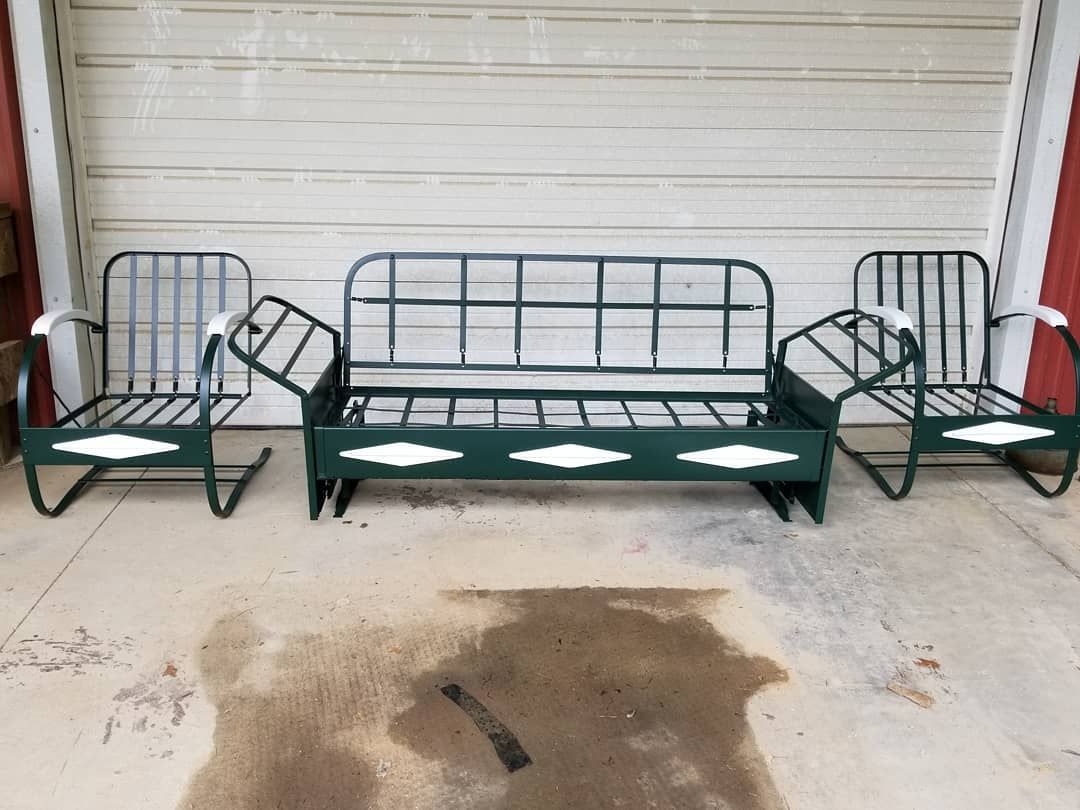 A couch and two chairs are sitting in front of a garage door.